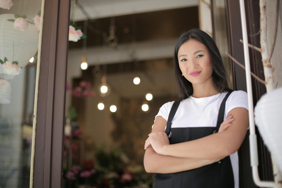 Small business owner standing confidently in her shop doorway